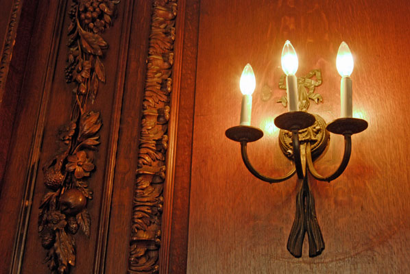 a wall sconce and ornate woodwork in Casa Loma