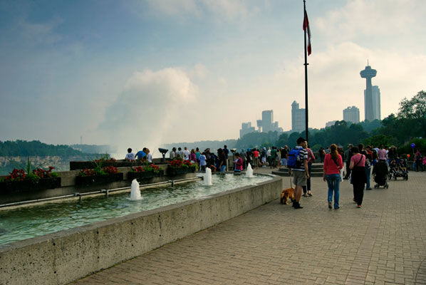 a plume of mist rises in the distance as seen from the walkway beside the Niagara gorge